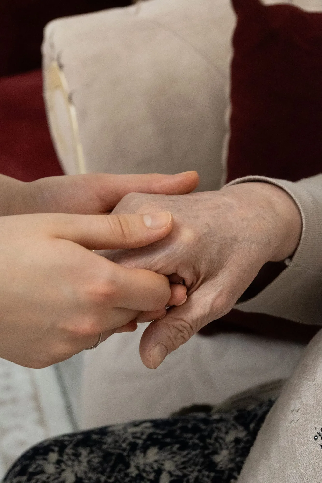 Hände einer Pflegekraft halten die Hand einer älteren Person